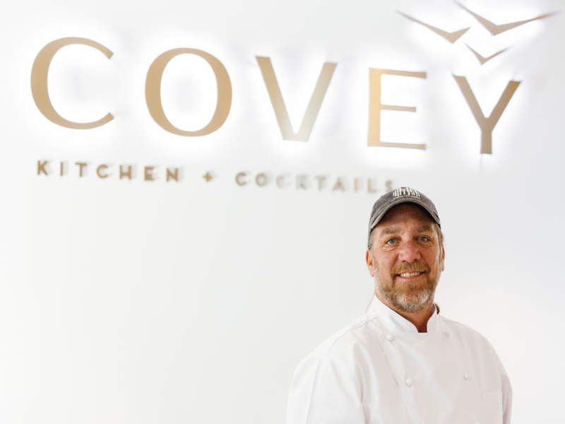 Chef Niedenthal stands under Covey sign