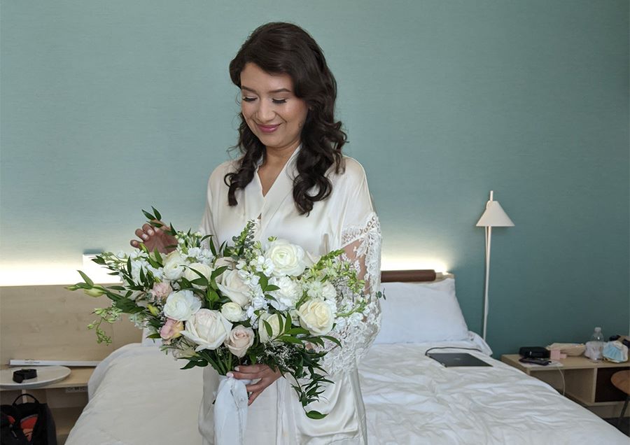 Ana and Brian held an intimate wedding in Gainesville, FL in November 2020. This photo is of the bride in her room at Hotel ELEO holding her flowers.